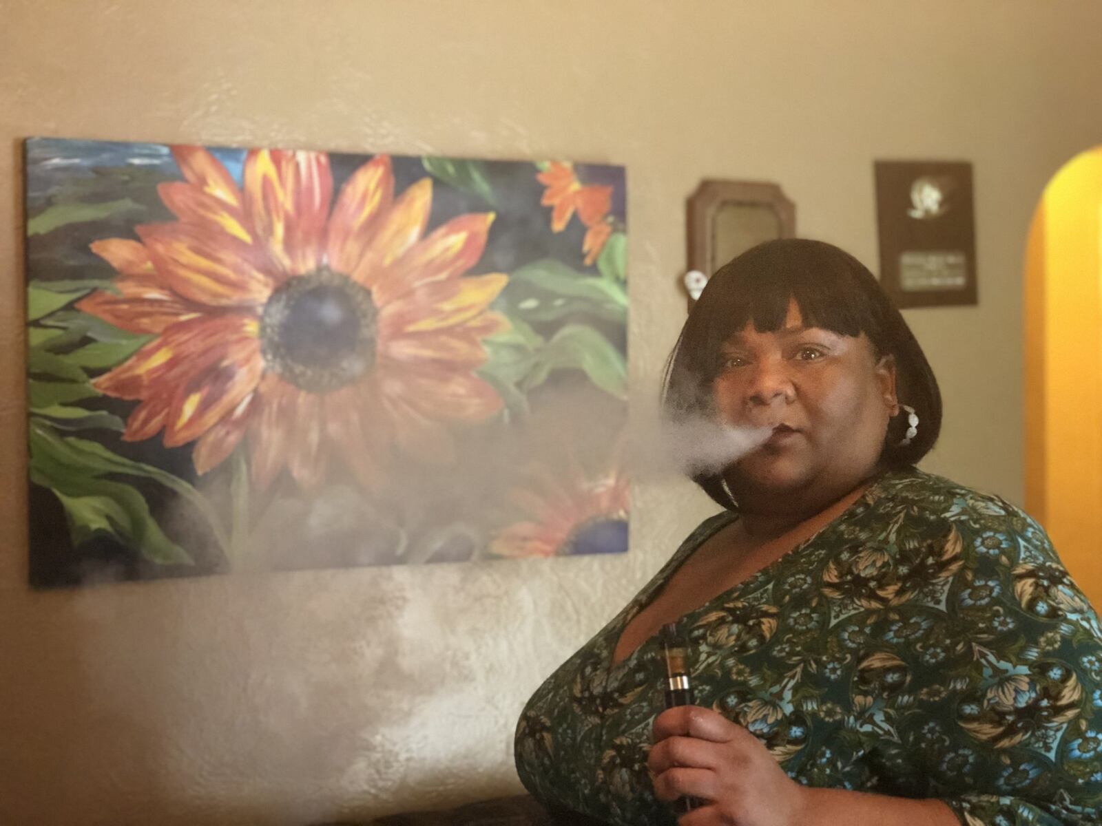 Tasha Rountree, a medical marijuana patient, advocate and entrepreneur, asked the city of Dayton to consider decriminalization back in May. Dayton leaders have credited Rountree with convincing them to put the decriminalization question on the Nov. 6 ballot. Rountree is seen here at her home vaping CBD oil. CORNELIUS FROLIK / STAFF