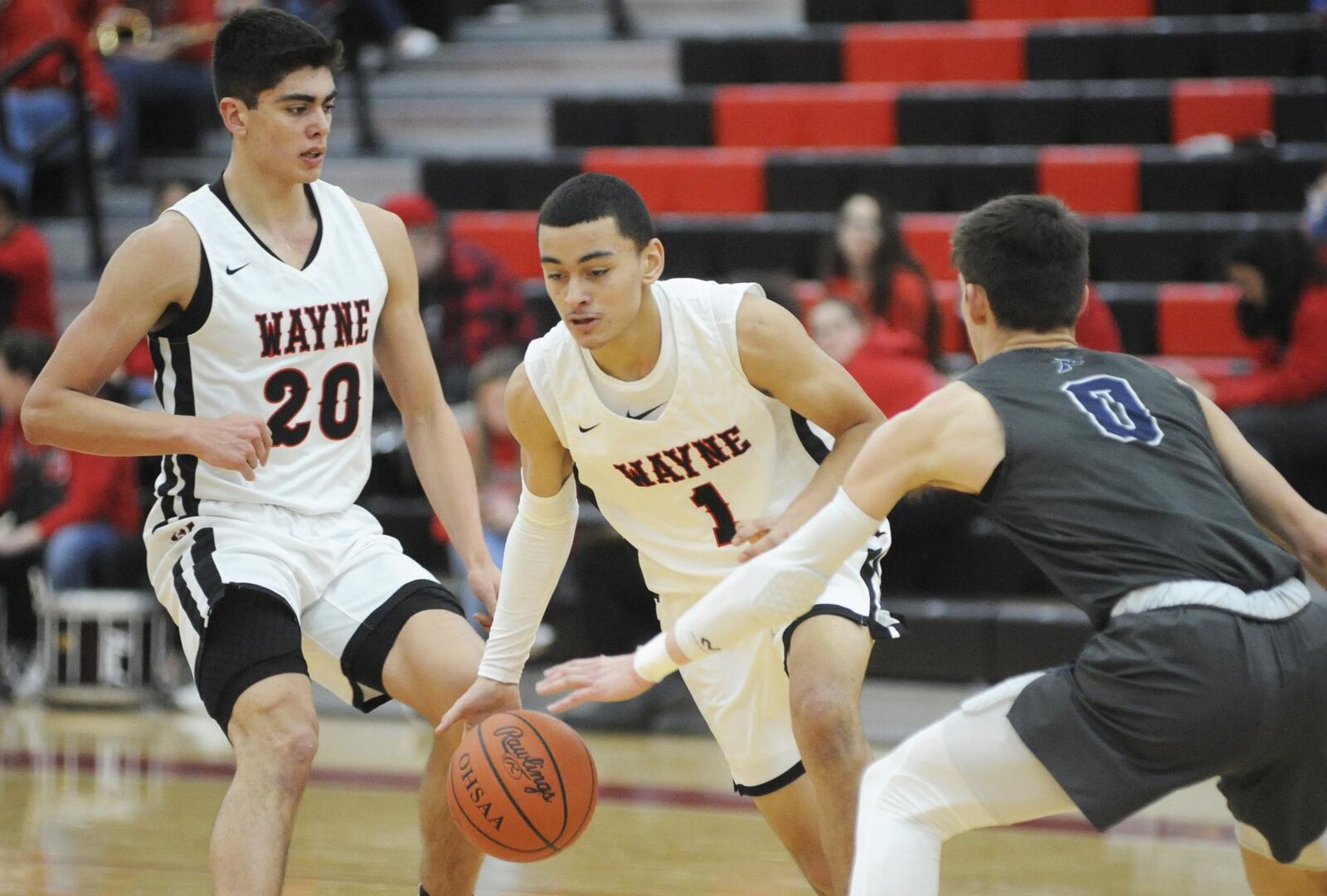 Cam Fancher of Wayne (with ball) splits teammate Bobby Cole (left) and Ryan Hall of Fairmont. Wayne defeated visiting Fairmont 58-38 in a boys high school basketball game on Tuesday, Jan. 29, 2019. MARC PENDLETON / STAFF
