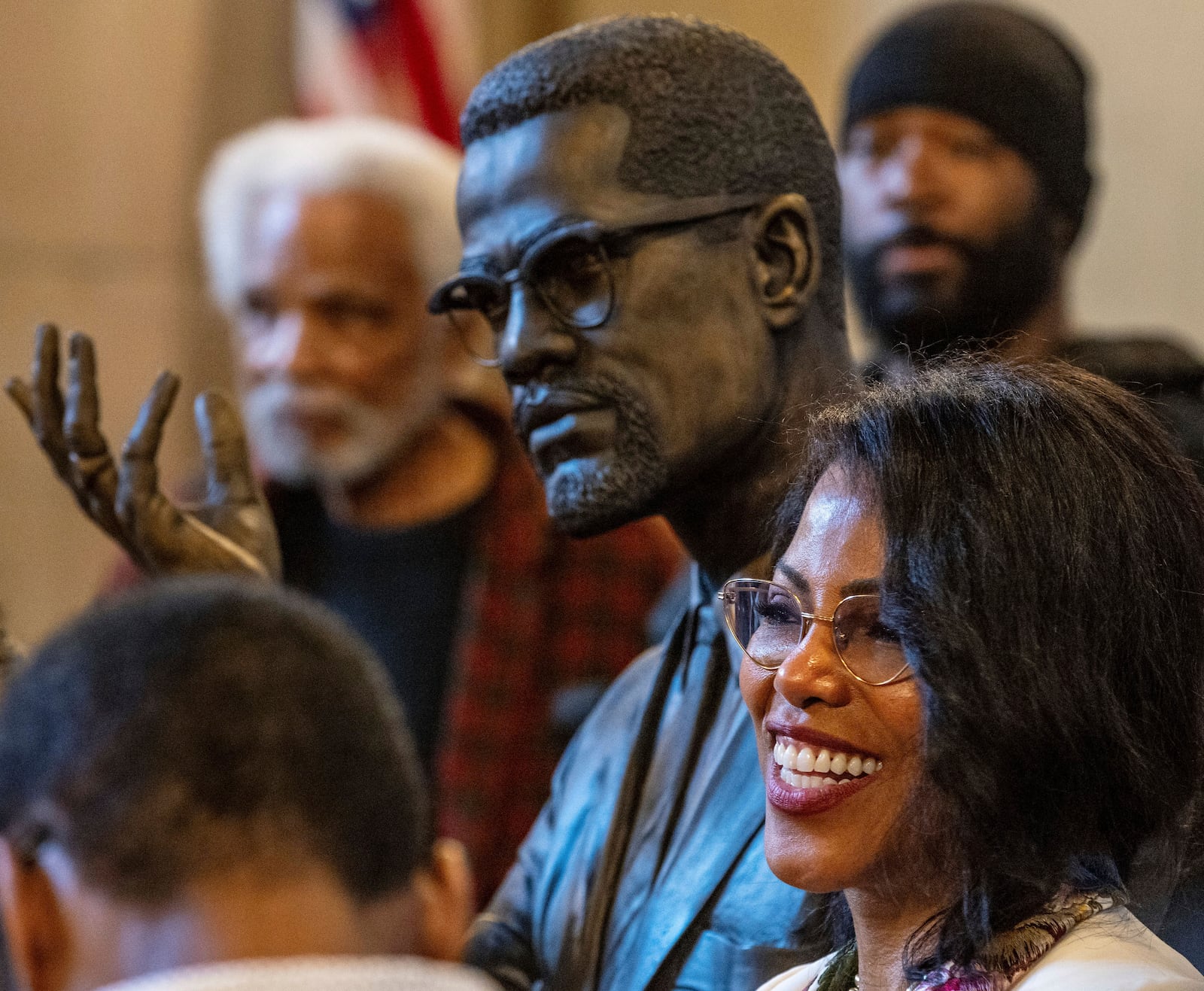Ilyasah Shabazz poses for a photo of the bust of her father, Malcolm X, after he was inducted into the Nebraska Hall of Fame during a ceremony in the Warner Legislative Chamber in Lincoln, Neb., on Wednesday, May 22, 2024. (Chris Machian/Omaha World-Herald via AP)