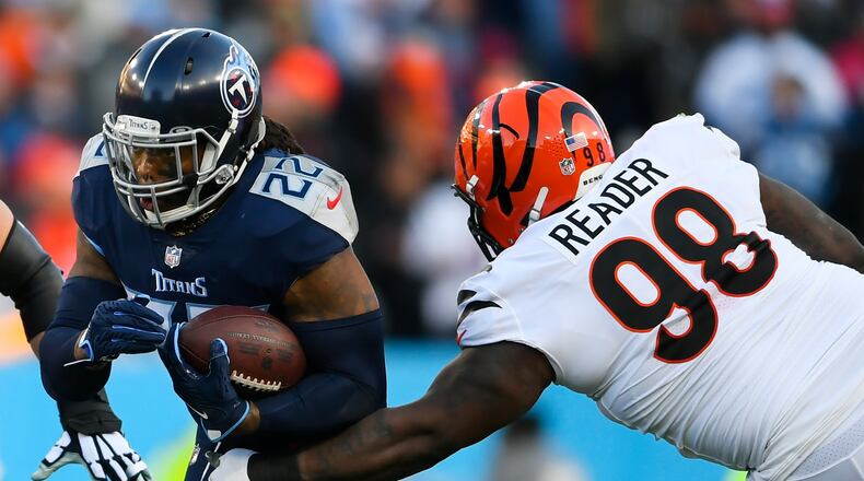 Tennessee Titans running back Derrick Henry (22) runs near Cincinnati Bengals nose tackle D.J. Reader (98) during the first half of an NFL divisional round playoff football game, Saturday, Jan. 22, 2022, in Nashville, Tenn. (AP Photo/John Amis)