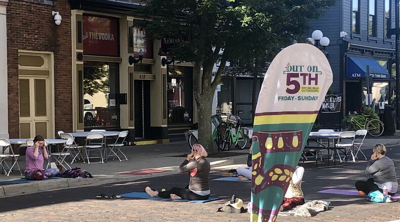Eclipse Leavy, of Laughing Fox Metacine, leads a yoga class in front of 416 Diner in the Oregon District. CONTRIBUTED/DEBBIE JUNIEWICZ