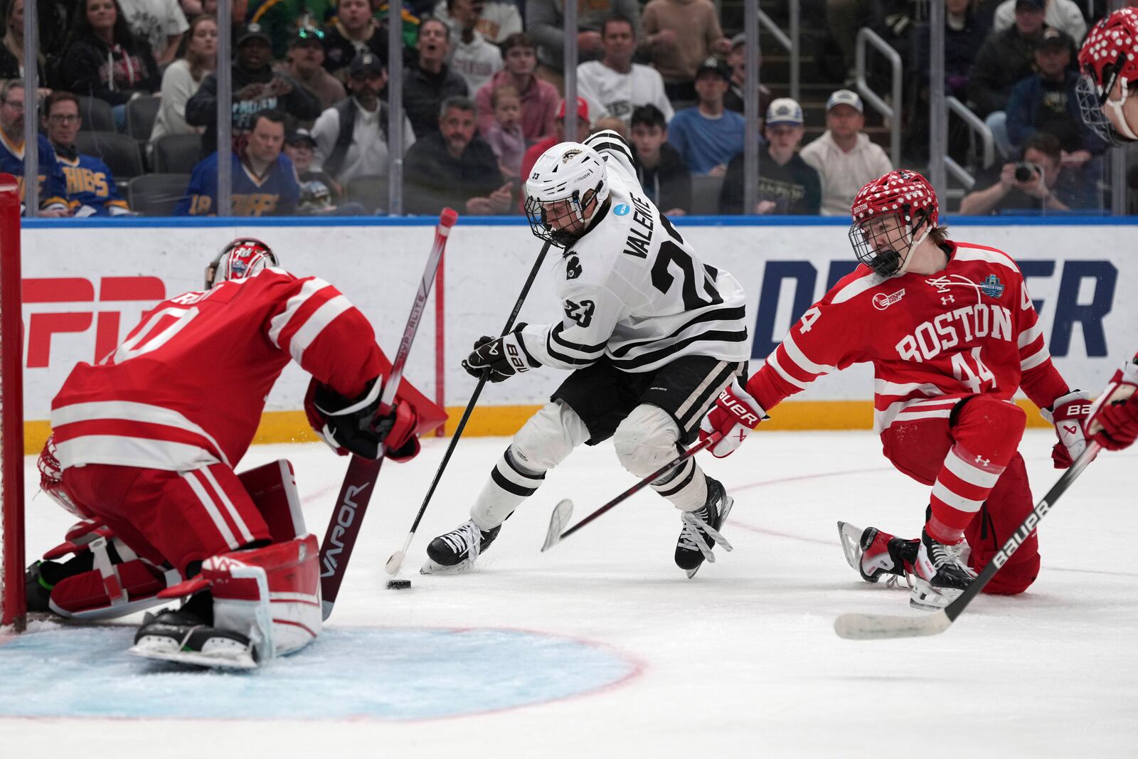 Western Michigan's Liam Valente (23) handles the puck as Boston University goaltender Mikhail Yegorov, left, and Cole Hutson (44) defend during the first period in the championship game of the NCAA Frozen Four men's college hockey tournament, Saturday, April 12, 2025, in St. Louis (AP Photo/Jeff Roberson)