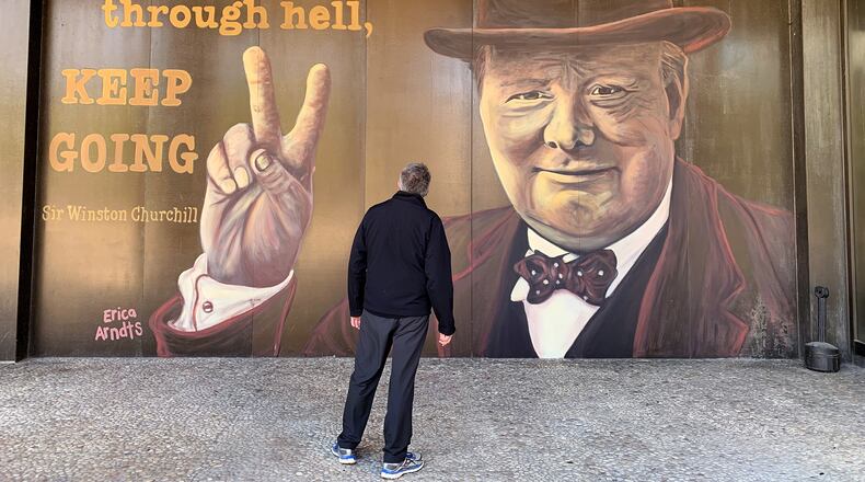 Winston Churchill, prime minister of Great Britain during much of World War II, is the subject of the latest downtown Dayton mural on the Stratacache Tower. The image of Churchill, painted by mural artist Erica Arndts, is accompanied by a quote he is associated with, âIf you are going through hell, keep going.â LISA POWELL / STAFF