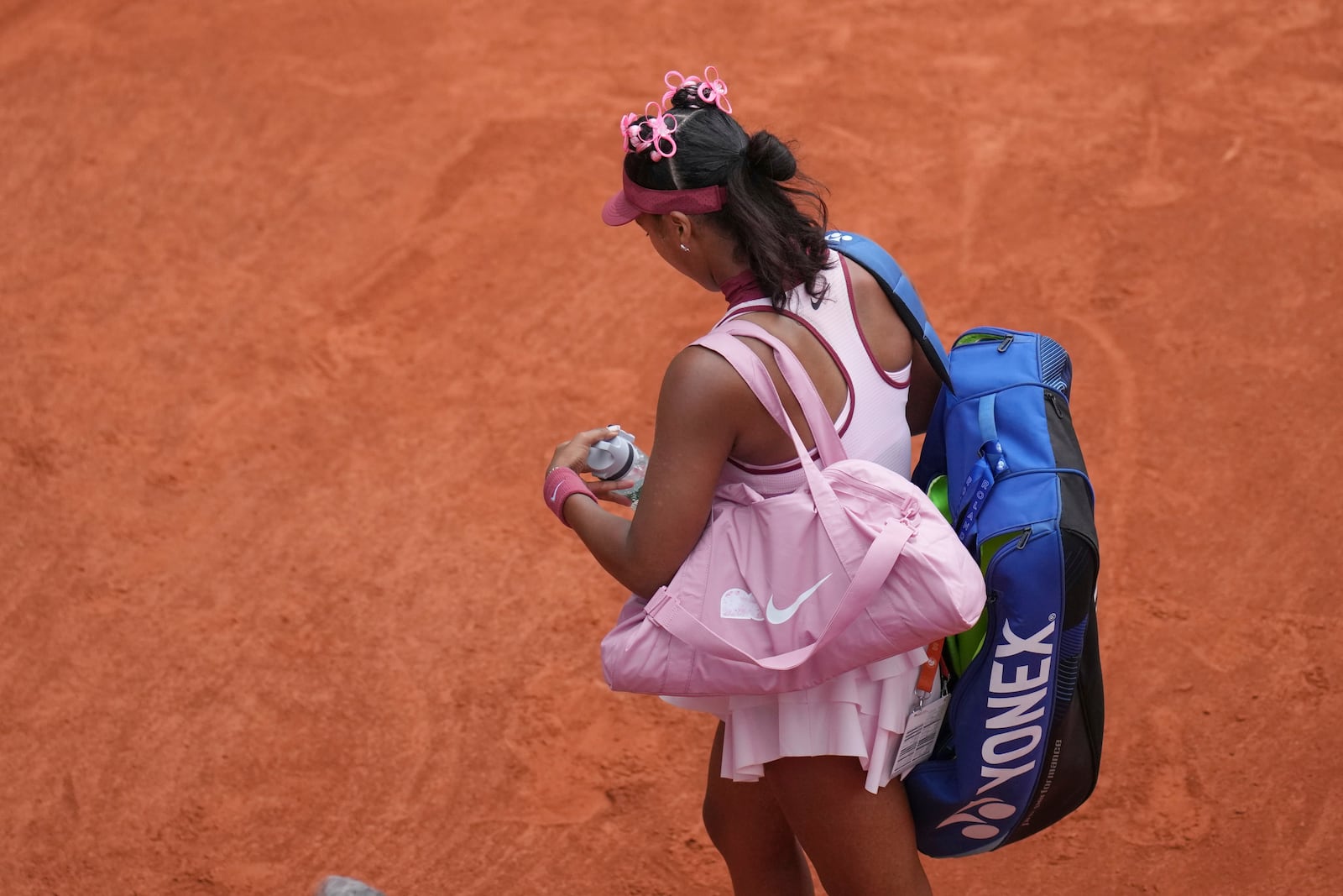 Japan's Naomi Osaka leaves after loosing to Spain's Paula Badosa during their first round match of the French Tennis Open, at the Roland-Garros stadium, in Paris, Monday, May 26, 2025. (AP Photo/Christophe Ena)