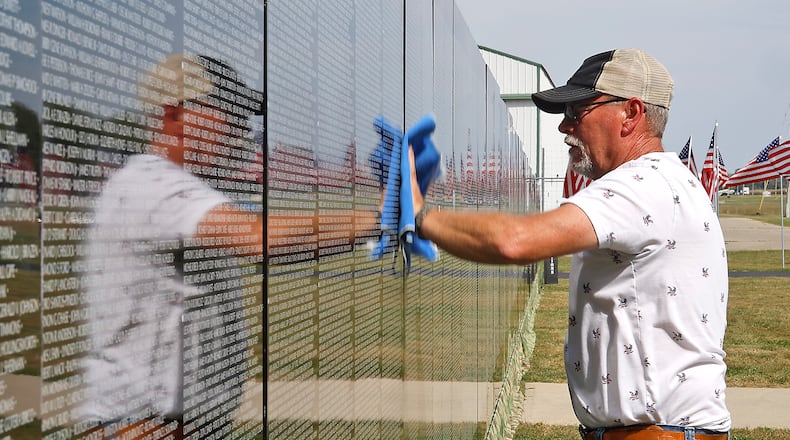 Craig Bennett, Commander of VFW Post #5451, wipes off the panels that make up The Moving Wall, a half size replica of the Vietnam Veterans Memorial in Washington, D.C. Thursday, Sept. 21, 2023 in Urbana. The Moving Wall, located in front of the Mid America Flight Museum at Grimes Field, arrived Thursday morning and will be open to the public 24 hours a day until Monday, Sept. 25. A public ceremony will be held at 10 a.m. on Saturday at the wall location. The Moving Wall's visit to Urbana is Sponsored by the Grimes Foundation and the Urbana VFW 5451. The Wall is one of two replicas of the Vietnam Veterans Memorial that travels around the country. BILL LACKEY/STAFF