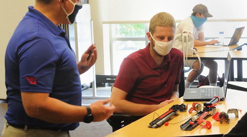 Dathan Erdahl, left, an instructor in the engineering department at the University of Dayton, discusses a project with student Austin Andwan during the first day of in-person instruction on campus Wednesday. MARSHALL GORBY/STAFF