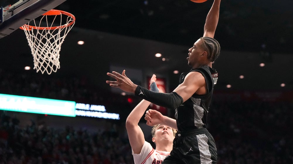 Cincinnati forward Baba Miller (18) dunks over Arizona center Motiejus Krivas during the first half of an NCAA college basketball game, Wednesday, Jan. 21, 2026, in Tucson, Ariz. (AP Photo/Rick Scuteri)