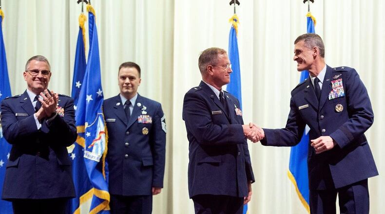 Brig. Gen. James H. Dienst (center), 711th Human Performance Wing commander, shakes hands with Brig. Gen. Mark Koeniger, June 21, a few seconds after assuming command of the wing during a ceremony presided over by Maj. Gen. William T. Cooley, Air Force Research Laboratory commander, in the National Museum of the U.S. Air Force. Dienst took over command from Koeniger who had commanded the wing for the past three years.