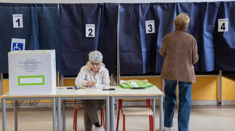 A woman arrives to vote in a referendum on judicial reform, at a polling station in Milan, Italy, Sunday March 22, 2026. (Marco Ottico/Lapresse via AP)