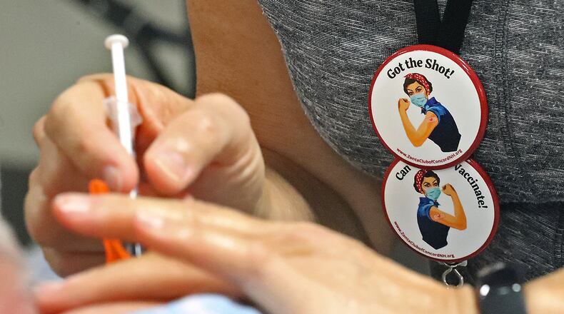 A Clark County resident gets a COVID vaccine shot Thursday at the Clark County Combined Health District's new vaccine center on Leffel Lane. BILL LACKEY/STAFF