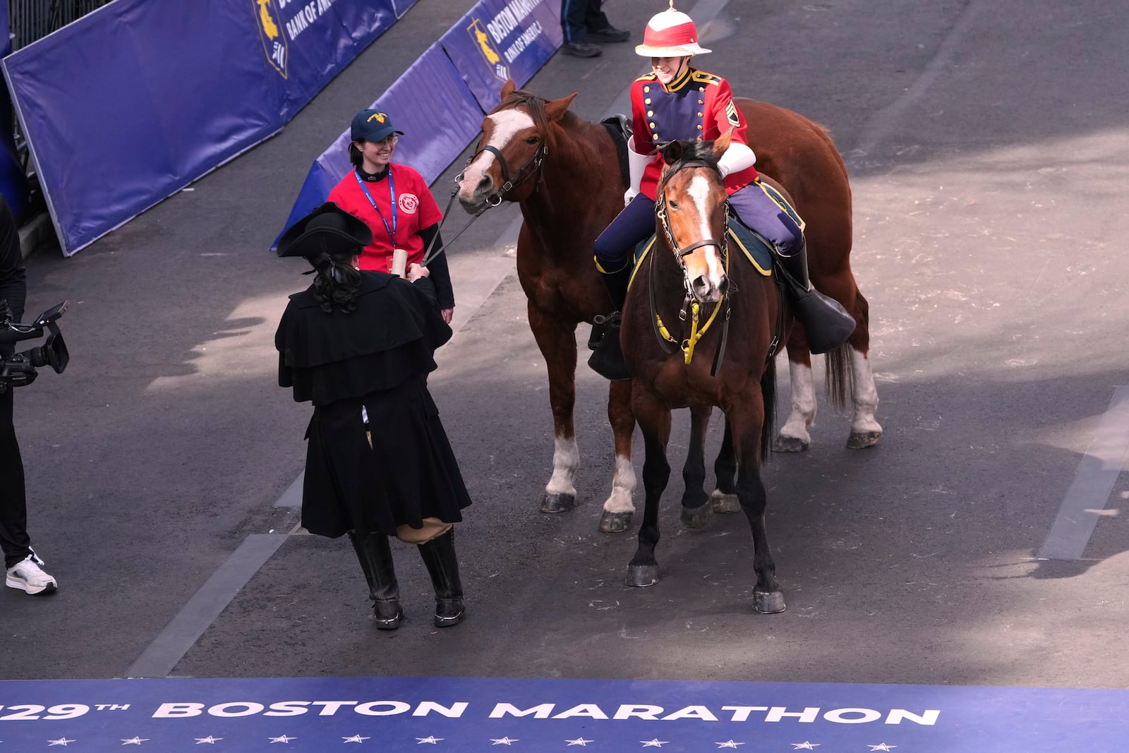 An actor portraying Paul Revere tries to pull his horse, which refused to advance over the line, during a ceremony for the Patriot's Day holiday at the finish prior to the Boston Marathon, Monday, April 21, 2025, in Boston. (AP Photo/Charles Krupa)