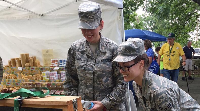 Airman 1st Class Hannah Graves (left), and Airman 1st Class Lillian Levy, both of the Bioenvironmental Sciences Engineer Squadron, 88th Medical Group, investigate a demonstration bee hive during the 3rd annual Pollinator Expo, Wright Memorial, Wright-Patterson Air Force Base June 19. (Skywrighter photo/Amy Rollins)
