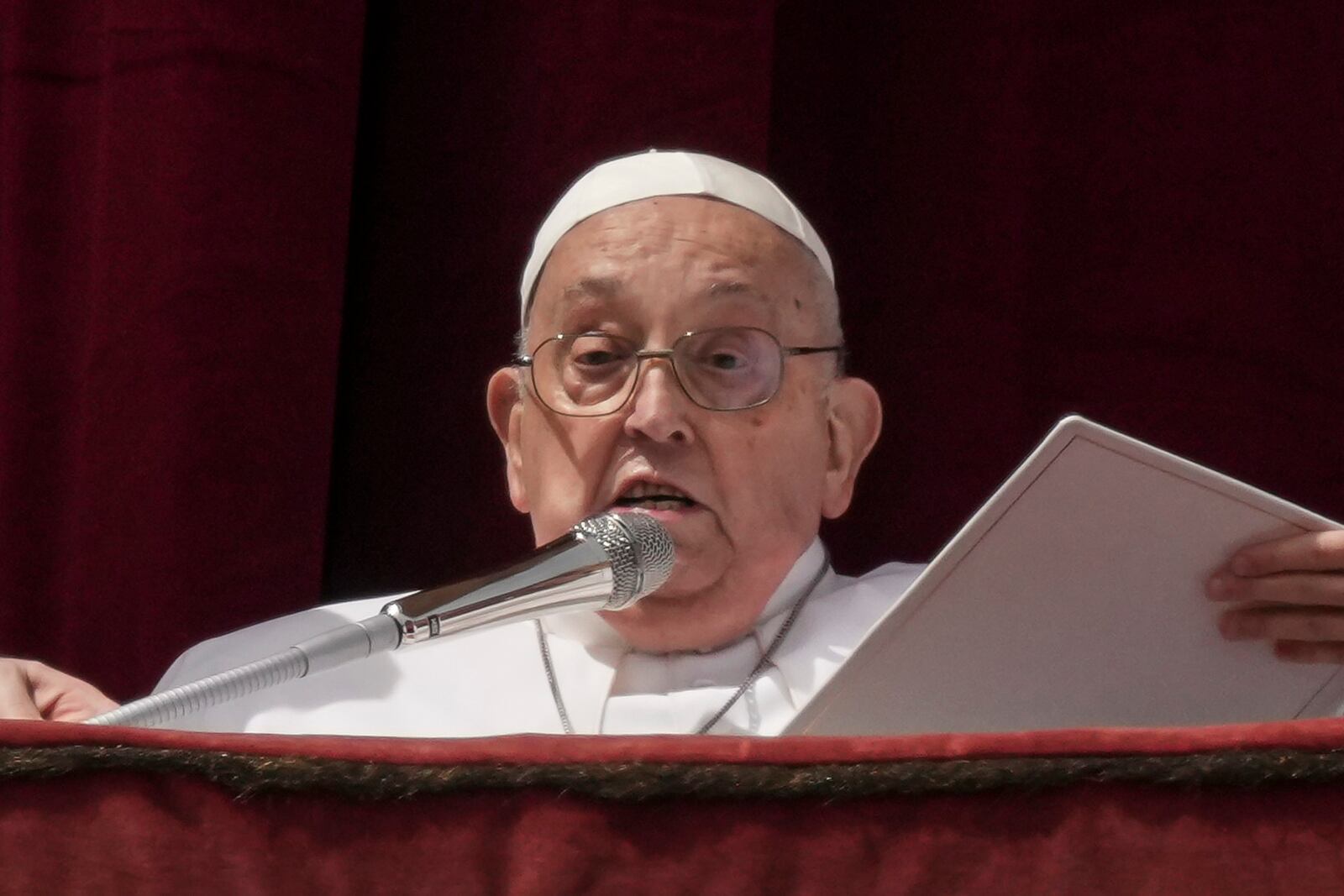 Pope Francis bestows the Urbi et Orbi (Latin for to the city and to the world) blessing from the central lodge of St. Peter's Basilica at the end of the Easter mass presided over by Cardinal Angelo Comastri in St. Peter's Square at the Vatican Sunday, April 20, 2025. (AP Photo/Andrew Medichini)