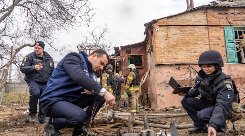 Police officers examine the fragments of a Russian drone that hit a private house during air attack in Kharkiv, Ukraine, Wednesday, March 25, 2026. (AP Photo/Andrii Marienko)