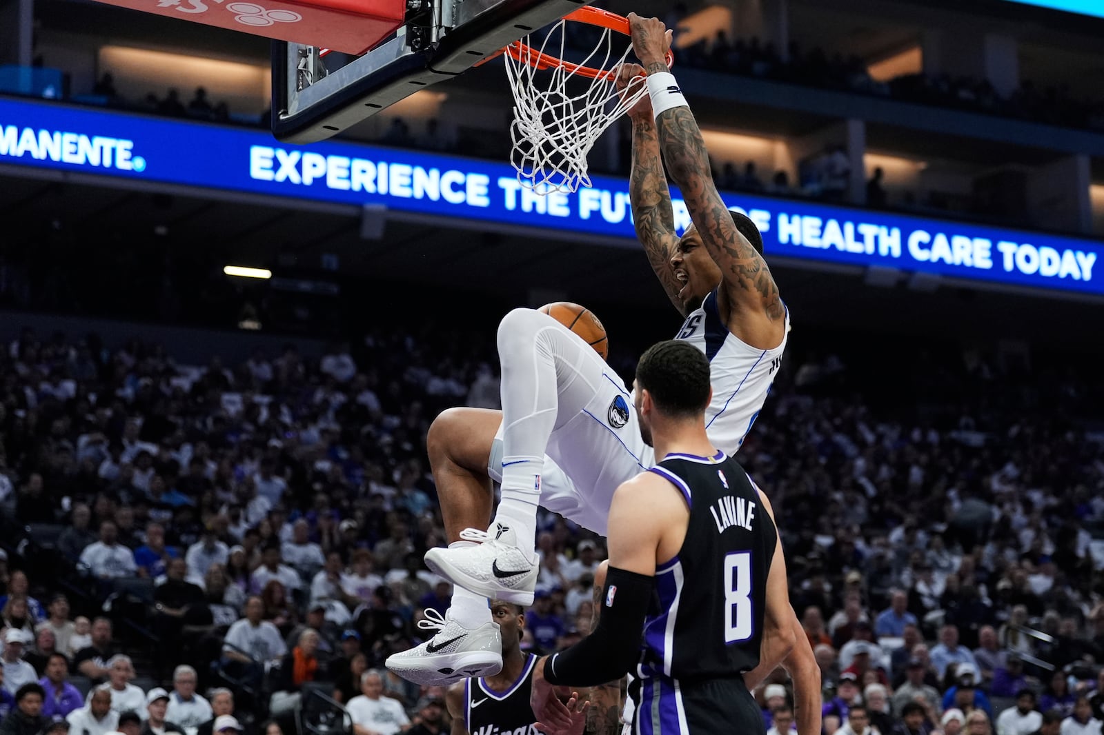 Dallas Mavericks forward P.J. Washington, center, dunks next to Sacramento Kings guard Zach LaVine (8) during the first half of an NBA play-in tournament basketball game Wednesday, April 16, 2025, in Sacramento, Calif. (AP Photo/Godofredo A. Vásquez)