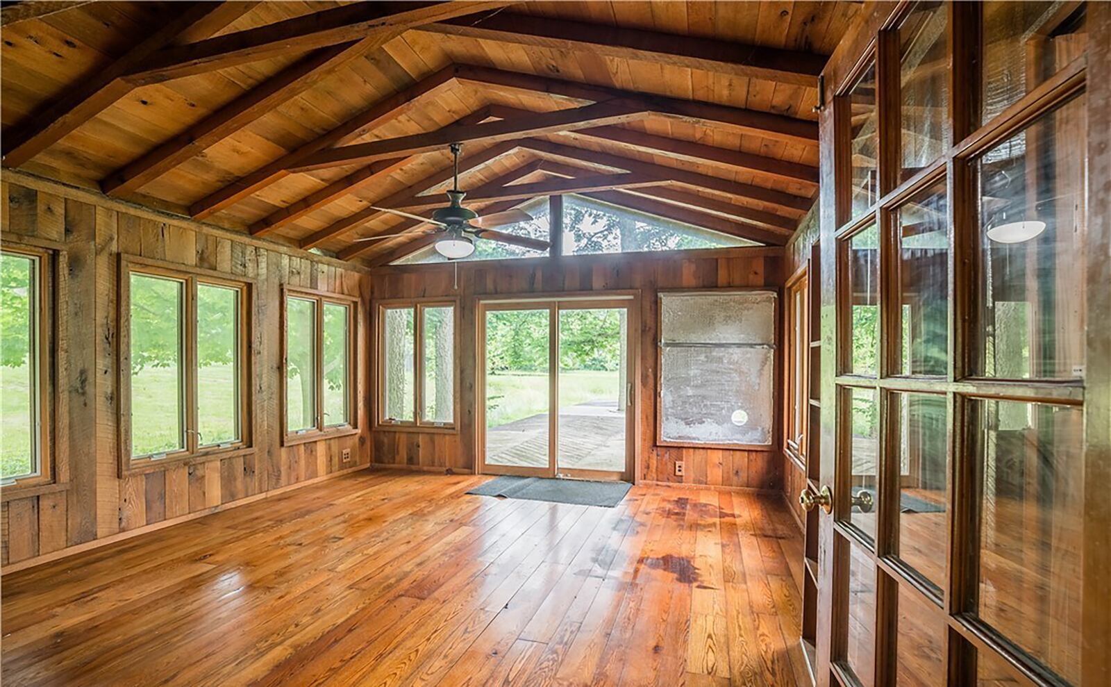 The house has a sunroom with beamed wood ceiling and wood paneled walls as well as wood flooring
