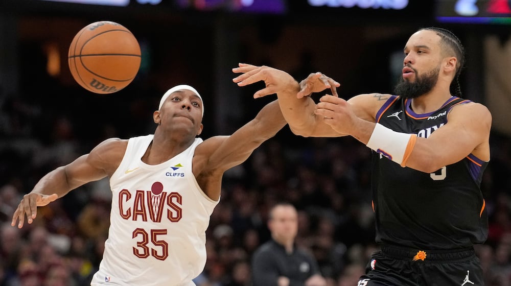 Phoenix Suns forward Dillon Brooks, right, passes around Cleveland Cavaliers forward Nae'Qwan Tomlin (35) in the second half of an NBA basketball game Wednesday, Dec. 31, 2025, in Cleveland. (AP Photo/Sue Ogrocki)