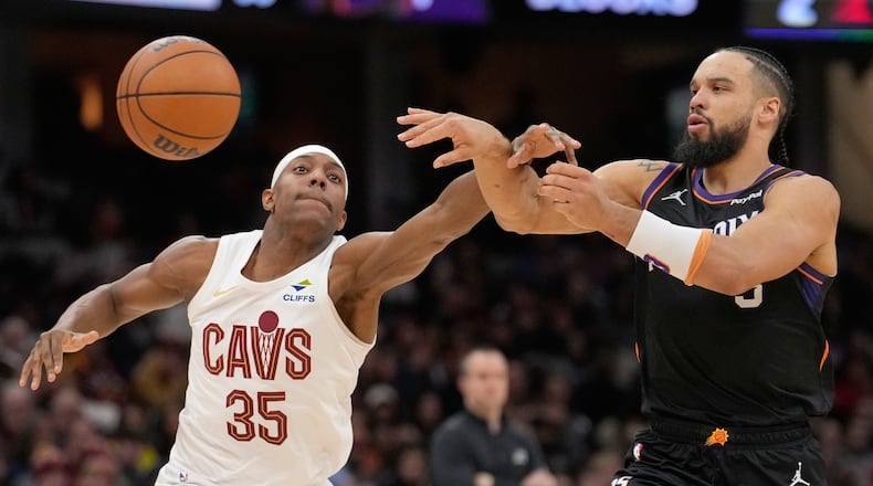 Phoenix Suns forward Dillon Brooks, right, passes around Cleveland Cavaliers forward Nae'Qwan Tomlin (35) in the second half of an NBA basketball game Wednesday, Dec. 31, 2025, in Cleveland. (AP Photo/Sue Ogrocki)