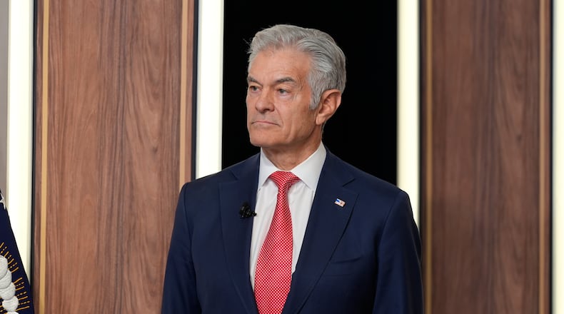 Centers for Medicare & Medicaid Services administrator Dr. Mehmet Oz listens as President Donald Trump speaks about TrumpRx in the South Court Auditorium in the Old Eisenhower Executive Office Building on the White House campus, Thursday, Feb. 5, 2026, in Washington. (AP Photo/Alex Brandon)
