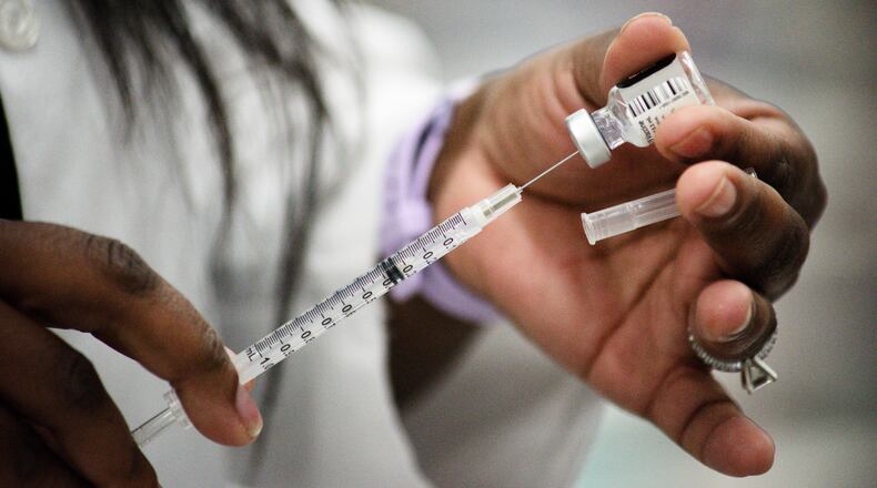 Kroger nurse practitioner Amanda Flowers prepares Covid-19 vaccines to be administered to school staff Wednesday, February 3, 2021 at Lakota West High School in West Chester Township. NICK GRAHAM / STAFF
