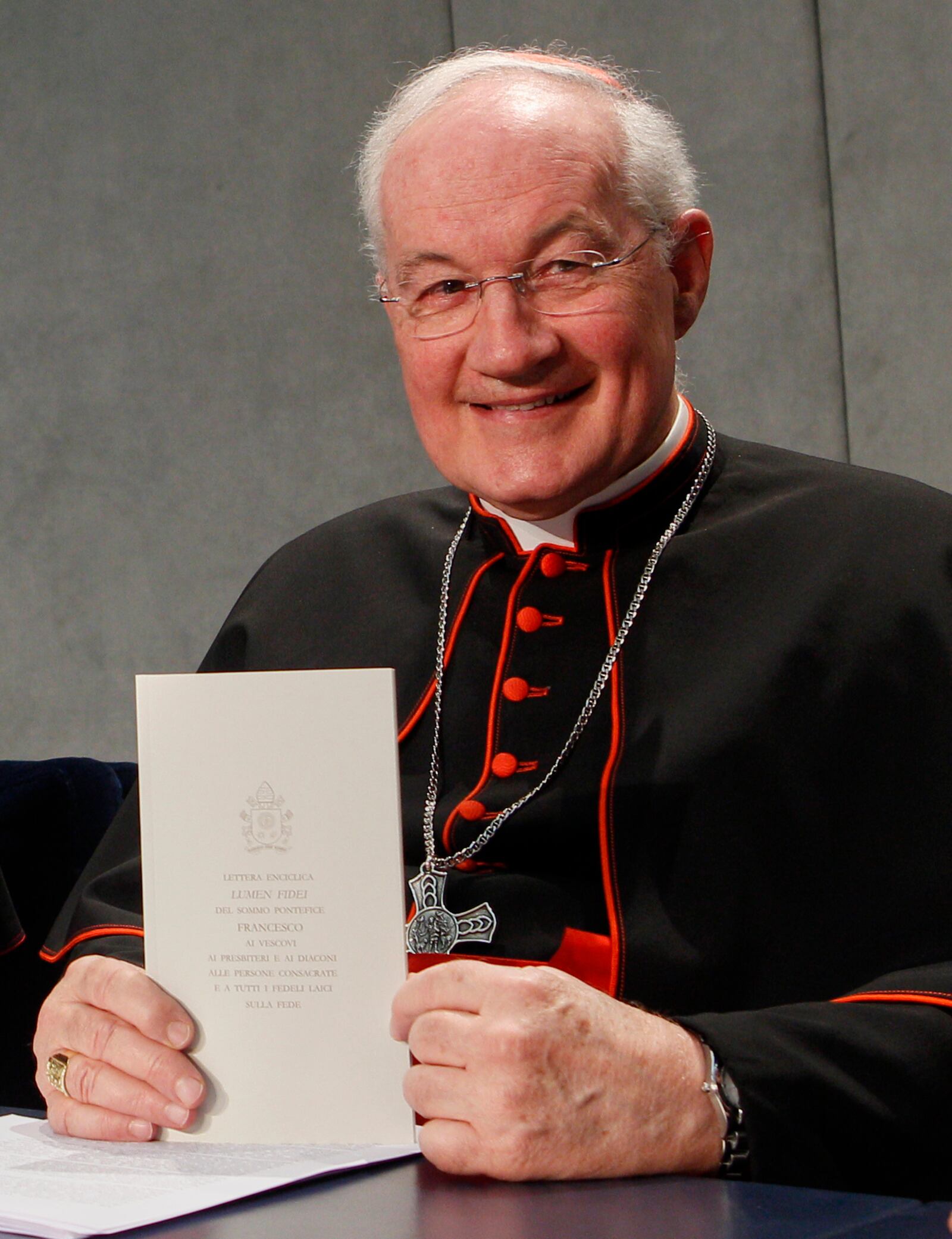 FILE - Cardinal Marc Ouellet shows a copy of the Pope Francis' Lumen Fidei encyclical letter prior to the start of a press conference for its presentation at the Vatican, Wednesday, July 3, 2013. (AP Photo/Riccardo De Luca, file)