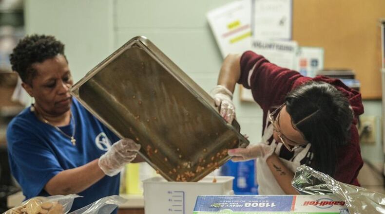 Cynthia Collier, left and Angel Gibson work in the kitchen at St. Vincent De Paul Society on Apple Street in Dayton. There is an unprecedented charitable need caused by the coronavirus, and as a result, #GivingTuesday on May 5, a day of giving, generosity and unity, has more significance this year. JIM NOELKER/STAFF