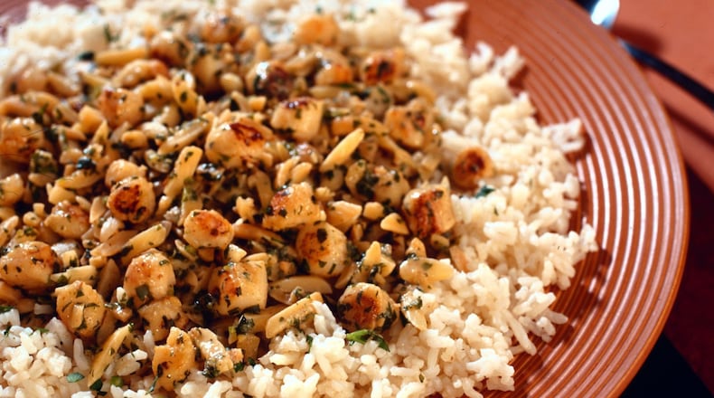 Scallops are sauteed, then mixed with lemon, almonds and garlic in a quick dinner that is yet complex and satisfying. (James F. Quinn/Chicago Tribune/TNS)