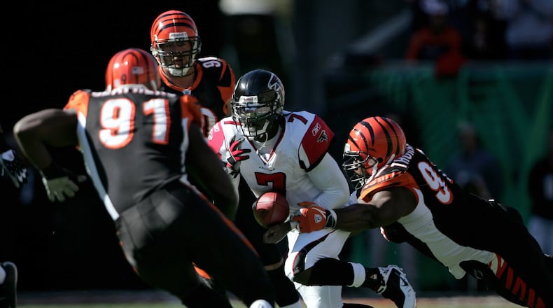 CINCINNATI - OCTOBER 29: Quarterback Michael Vick #7 of the Atlanta Falcons scrambles and has the ball knocked away by John Thornton #97 of the Cincinnati Bengals as Robert Geathers #91 and Justin Smith #90 pursue the play as the Falcons recovered the ball during the second quarter on October 29, 2006 at Paul Brown Stadium in Cincinnati, Ohio. (Photo by Doug Pensinger/Getty Images)
