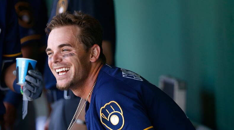 Milwaukee Brewers’ Scooter Gennett smiles as he sits down in the dugout after scoring a run against the San Francisco Giants during the fifth inning of a spring training baseball game Sunday, March 19, 2017, in Scottsdale, Ariz. (AP Photo/Ross D. Franklin)