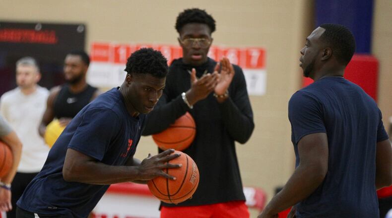 Dayton’s Moulaye Sissoko, left, works with grad assistant coach Khyle Marshall, right, as Jordy Tshimanga watches during a team workout on Monday, Sept. 23, 2019, at the Cronin Center. David Jablonski/Staff