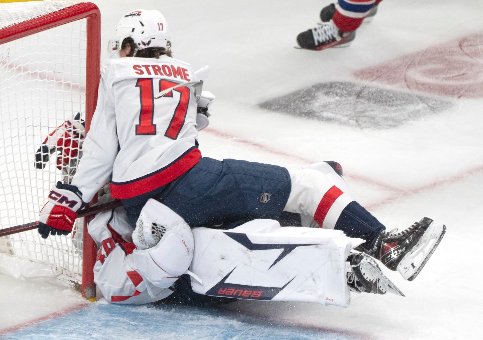 Washington Capitals' Dylan Strome (17) collides with goaltender Logan Thompson, bottom, during the third period of Game 3 of a first-round NHL hockey playoff series against the Montreal Canadiens in Montreal, Friday, April 25, 2025. (Christinne Muschi/The Canadian Press via AP)