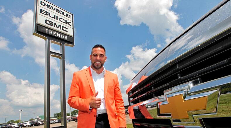 Steve VanGorder, of SVG Motors, poses under the Trenor Chevy, Buick and GMC sign in Urbana last summer. SVG Motors purchased Trenor, which had been family-run for decades. Bill Lackey/Staff