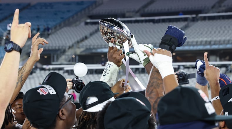 Virginia players hoist the trophy after defeating Missouri in the Gator Bowl NCAA college football game in Jacksonville, Fla., Saturday, Dec. 27, 2025. (AP Photo/Gary McCullough)