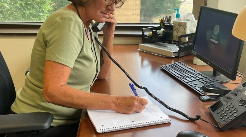 Laura R., clinical supervisor, at the hotline call room at the Artemis Center in Dayton. SAMANTHA WILDOW/STAFF