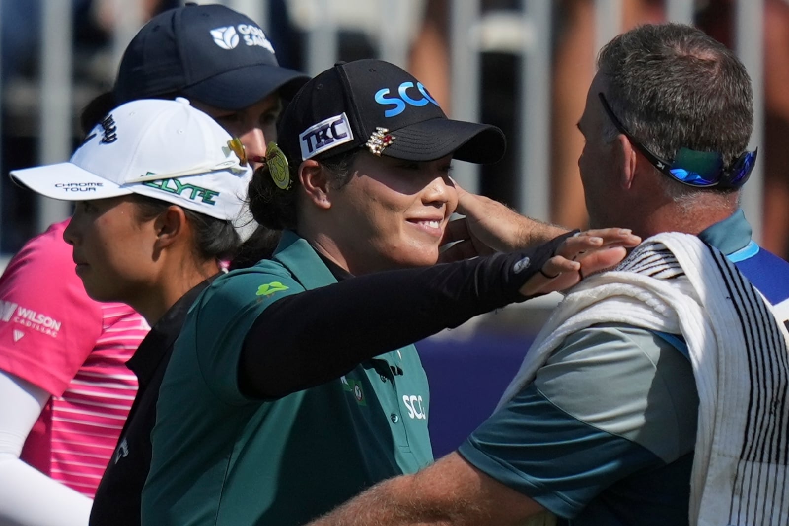 Ariya Jutanugarn, of Thailand, center, embraces a caddie on the 18th green during the final round of the Chevron Championship LPGA golf tournament Sunday, April 27, 2025, in The Woodlands, Texas. (AP Photo/Eric Gay)