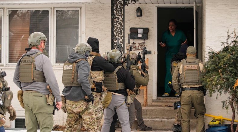 ADDS IDENTIFICATION: Teyana Gibson Brown, second from right, wife of Garrison Gibson, reacts after a federal immigration officer used a battering ram to break down a door before arresting Garrison Gibson, Sunday, Jan. 11, 2026, in Minneapolis. (AP Photo/John Locher)