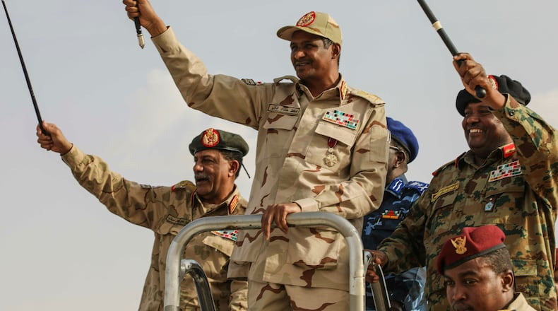 FILE - Gen. Mohammed Hamdan Dagalo, center, greets the crowd during a military-backed tribes' rally in the Nile River State of Sudan, July 13, 2019. (AP Photo/Mahmoud Hjaj, File)