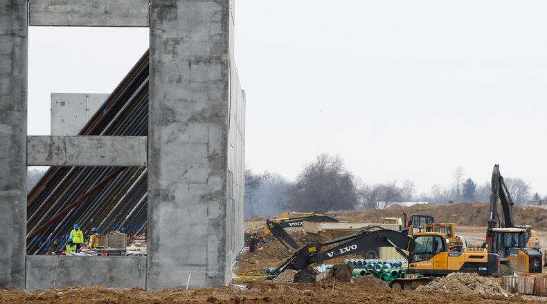 Long stabilizer bars run horizontally down from giant concrete wall sections at the new Crocs distribution center under construction at the Dayton Airport. TY GREENLEES / STAFF