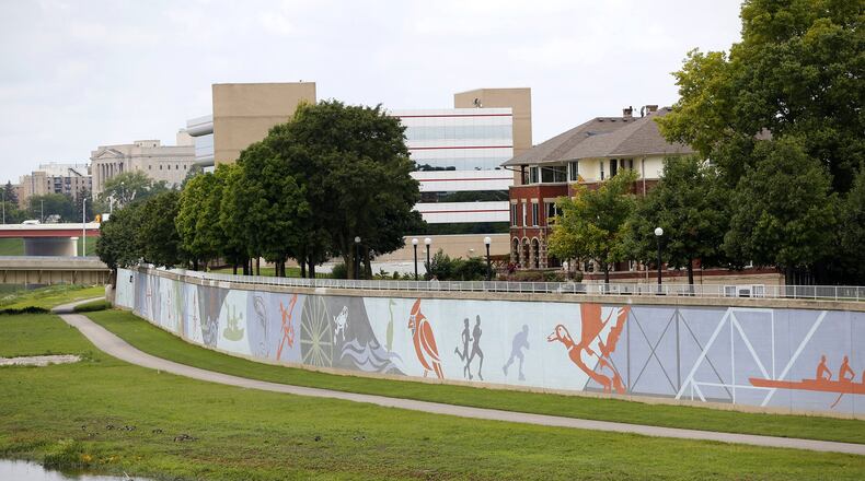 The River Run Mural spans 950 feet next to the Great Miami River across from RiverScape Metro Park. Designed by artist Amy Deal it was painted on the flood wall by artists from K12 Gallery. River Run opens on May 5 LISA POWELL / STAFF
