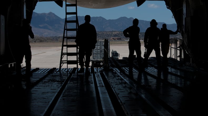 Airmen from the 21st Logistics Readiness Squadron, the 22nd Airlift Squadron watch as a K Loader is directed after putting cargo pallets onto a C-5M Super Galaxy in April. on Peterson Air Force Base, Colo. Peterson AFB photo