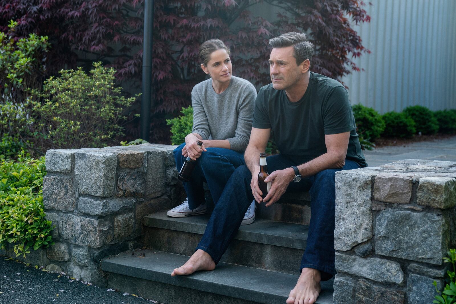 This image released by Apple TV+ shows Amanda Peet, left, and Jon Hamm in a scene from "Your Friends & Neighbors." (Jessica Kourkounis/Apple TV+ via AP)