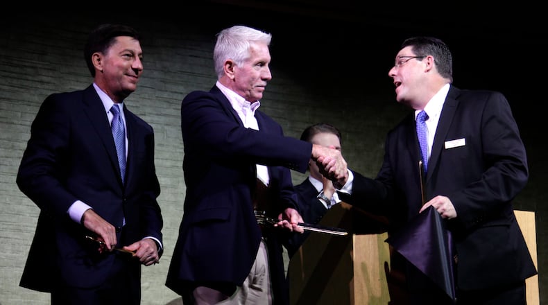 Baseball legend Mike Schmidt (center) shakes hands with Hollywood Gaming at Dayton Raceway general manager Gary DeWitt during the opening Thursday. At left is John Finamore, senior vice-president of regional operations for Penn National Gaming. The racino has over 1,000 video lottery terminals and will begin live harness racing in October. LISA POWELL / STAFF PHOTO