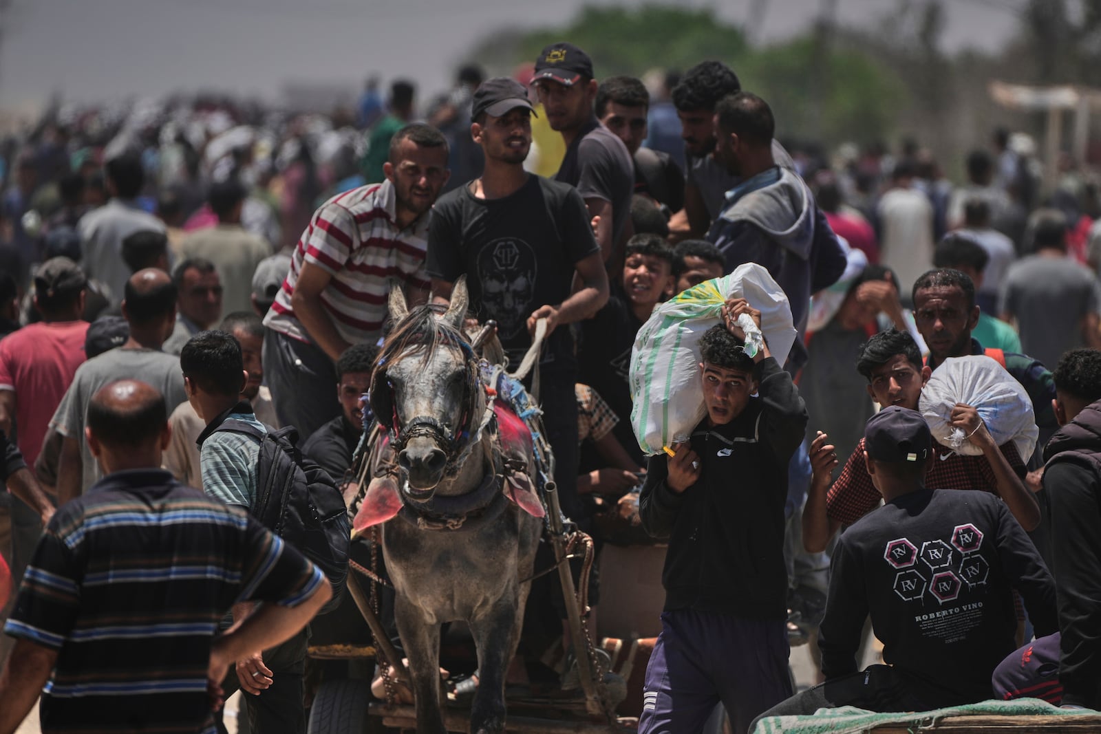 Palestinians carry bags containing food and humanitarian aid packages delivered by the Gaza Humanitarian Foundation, a U.S.-backed organization, in Rafah, southern Gaza Strip, Monday, June 9, 2025. (AP Photo/Abdel Kareem Hana)