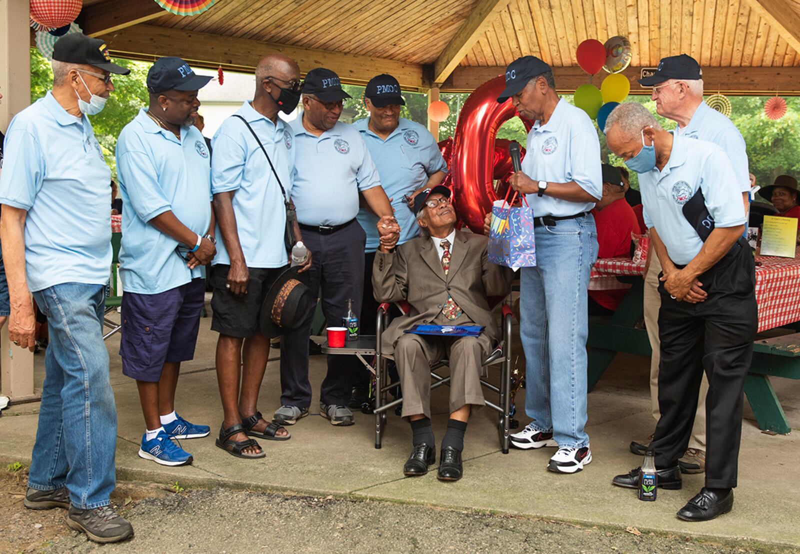 A group of men from the Protestant Chapel Community at Wright-Patterson Air Force Base presents Willie Parker (seated) with a gift during his 100th birthday celebration July 20 in Huber Heights. U.S. AIR FORCE PHOTO/WESLEY FARNSWORTH