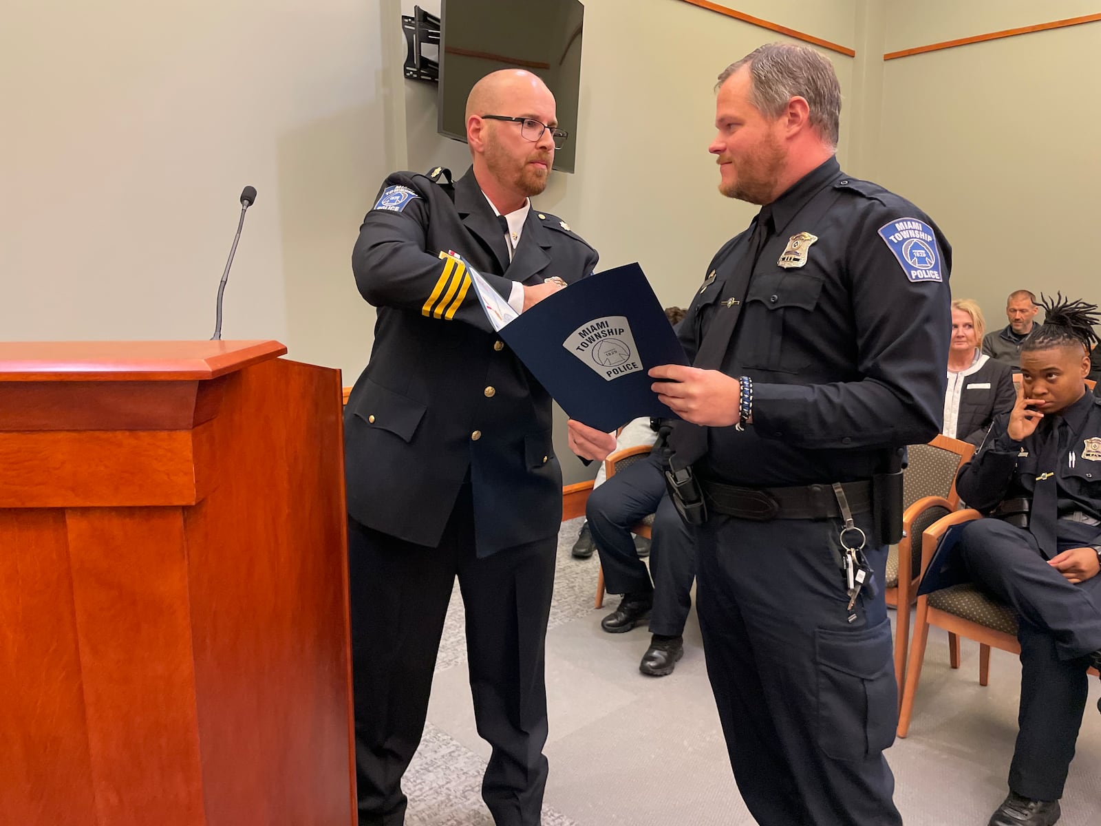 Miami Twp. police officer Matthew Randolph (right) is awarded a Life Saving Award from Acting Chief James McCarty at a Miami Twp. Board of Trustees meeting Tuesday, April 15, 2025. Officers Cody Lee and Danielle Schweickart received the same award, but were unable to attend the meeting. CONTRIBUTED