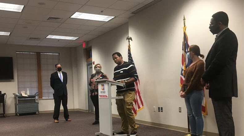 Congressman Mike Turner looks on as foster care youth advocate Jonathon Thomas speaks about how a change in law will impact future youth leaving the foster care system.