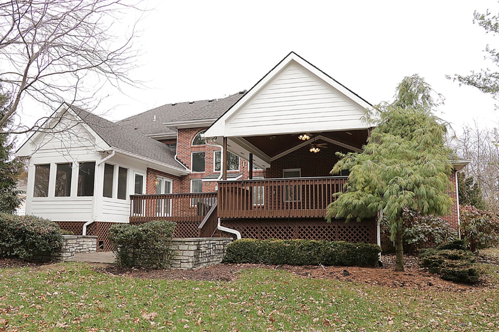 The back yard has mature trees providing added privacy to the 1-acre lot. A patio is below the composite sun deck, which wraps around to a covered deck with a cathedral roof. There is also a screen-enclosed porch that opens to the deck. CONTRIBUTED PHOTO BY KATHY TYLER