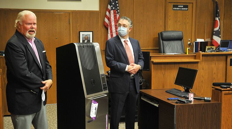 Montgomery County Common Pleas Judge Steven Dankof, left,  and Dr. David Kirschman, President of Aerobiotix, display the Illuvia air recirculation machine that the courts bought to run during jury trials and hearings. 
Implementing the air recirculation machines in courtrooms is one of many precautions the common pleas court has taken to keep jurors, defendants, lawyers and court staff safe during the coronavirus pandemic. MARSHALL GORBY\STAFF
