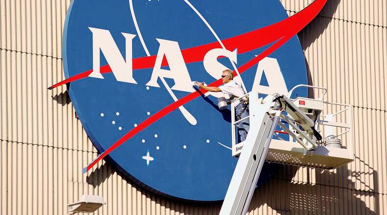 A painter freshens up the NASA logo that adorns NASA Glenn Research Center's Flight Research Building, or airplane hangar. Affectionately coined "the meatball," the blue logo makes the hangar the most recognized of NASA Glenn's facilities
