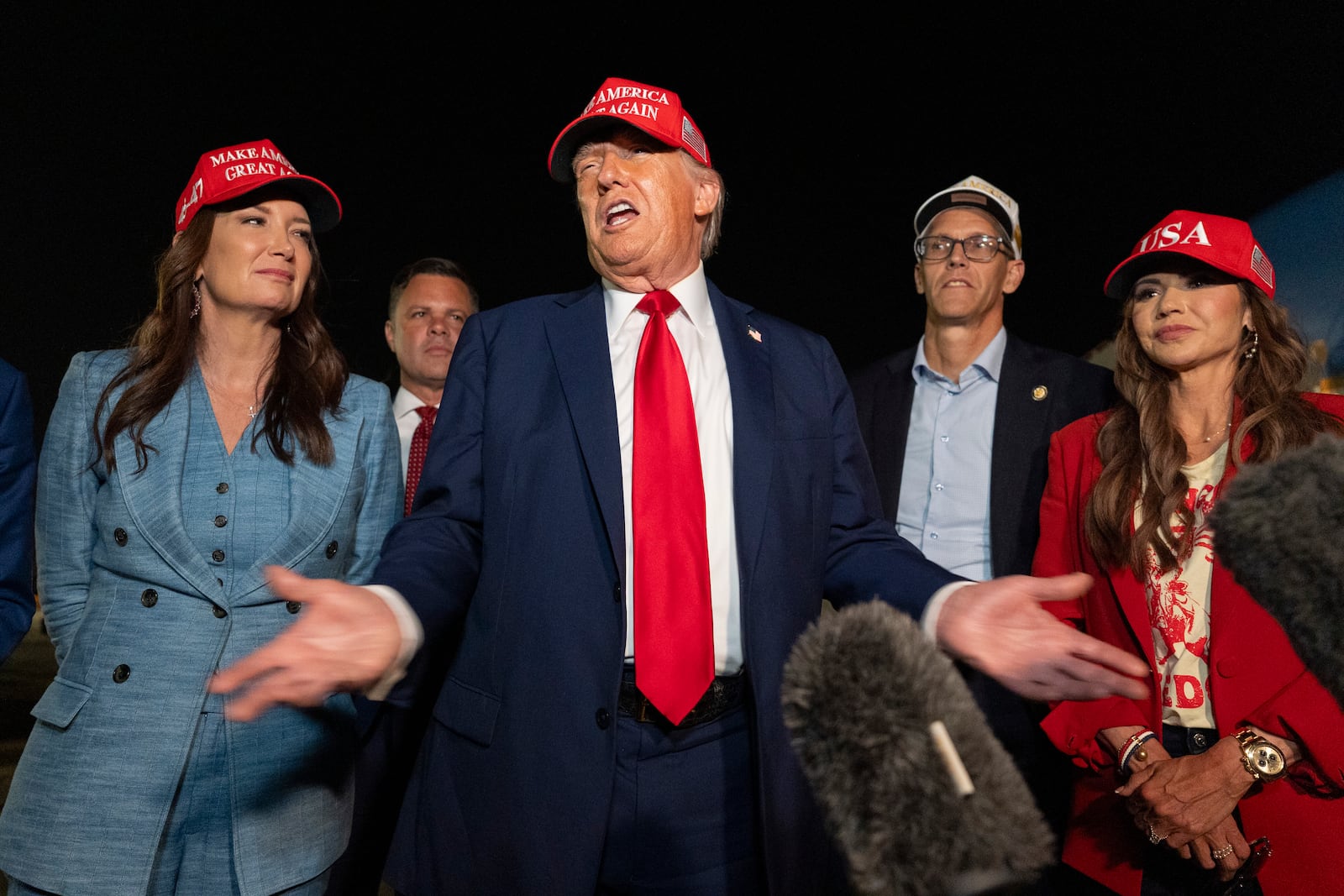 President Donald Trump, center, speaks with reporters as, from left, Agriculture Secretary Brooke Rollins, Rep. Zachary Nunn, R-Iowa, Rep. Randy Feenstra, R-Iowa, and Homeland Security Secretary Kristi Noem listen as they arrive on Air Force One, Friday, July 4, 2025, at Joint Base Andrews, Md. (AP Photo/Alex Brandon)